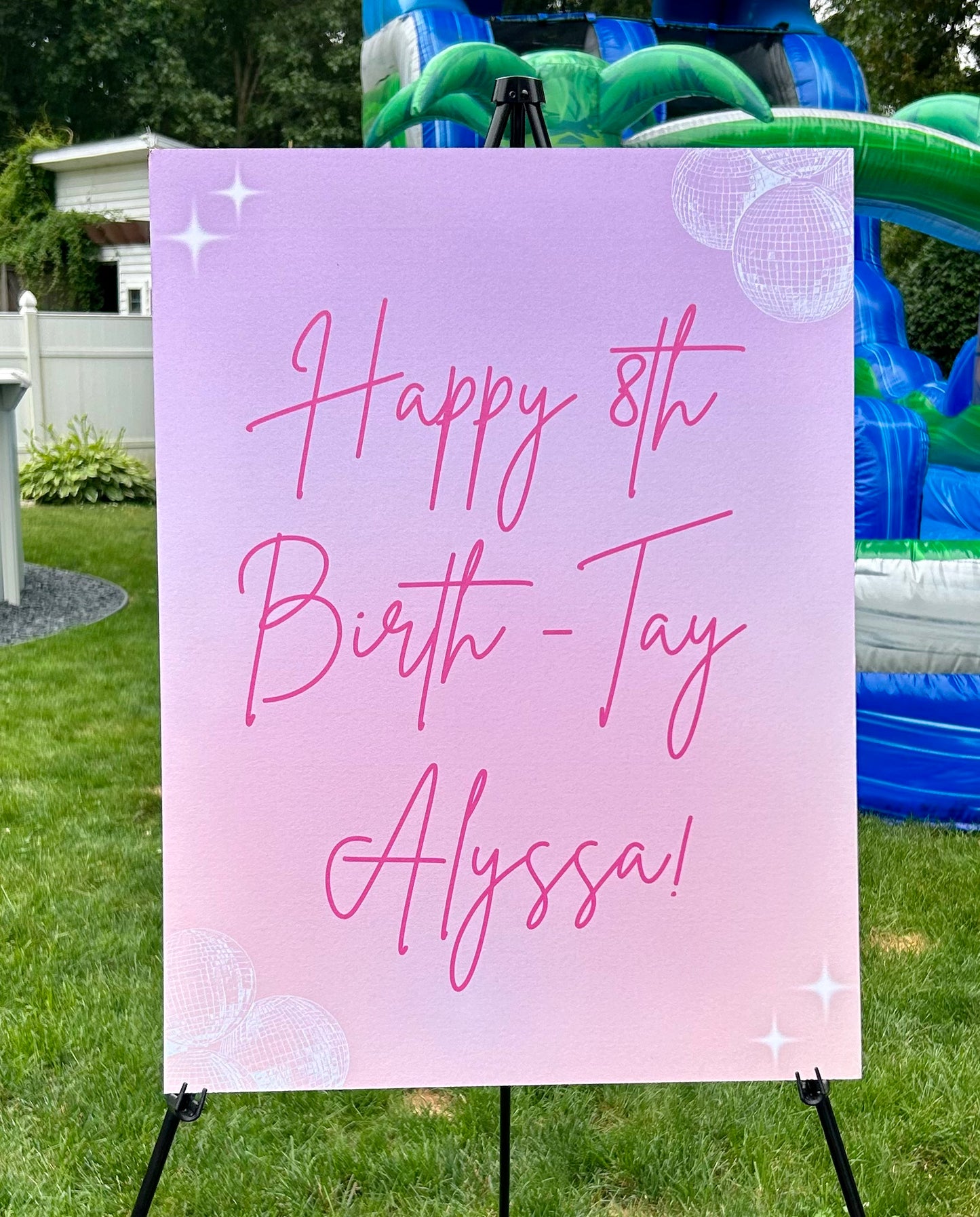 Pink birthday sign with 'Happy 8th Birth-Tay Alyssa!' text, placed outdoors.