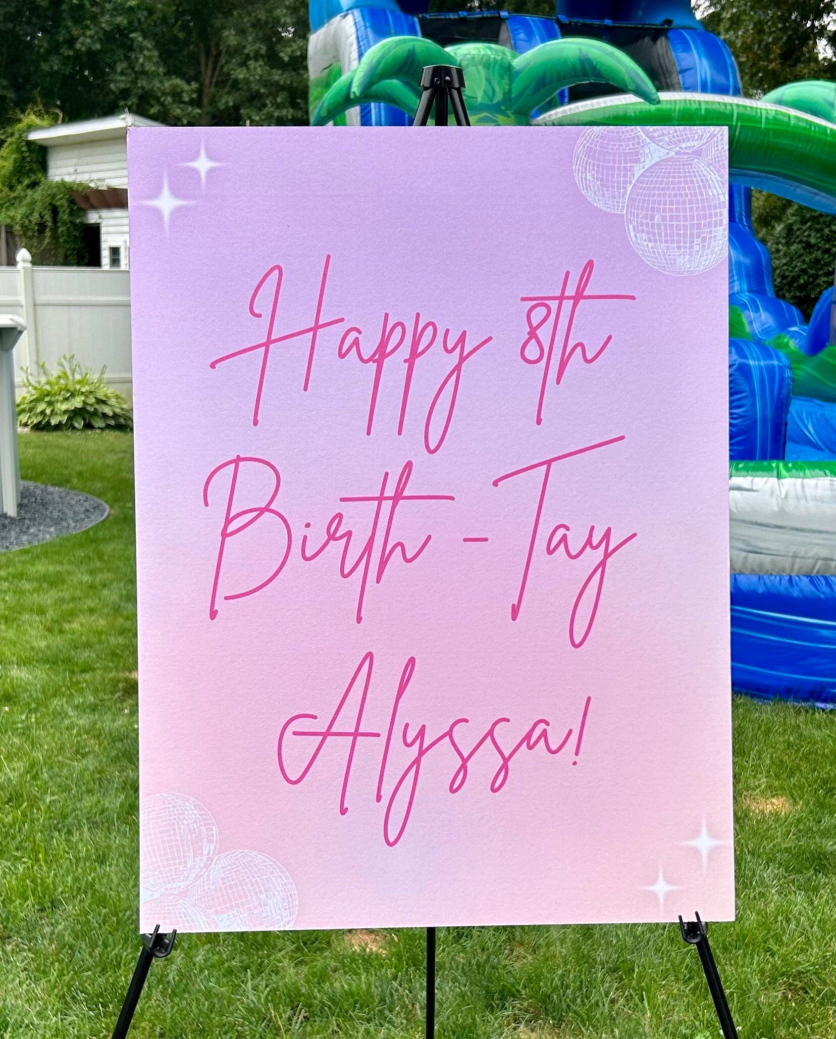 Pink birthday sign with 'Happy 8th Birth-Tay Alyssa!' text, placed outdoors.