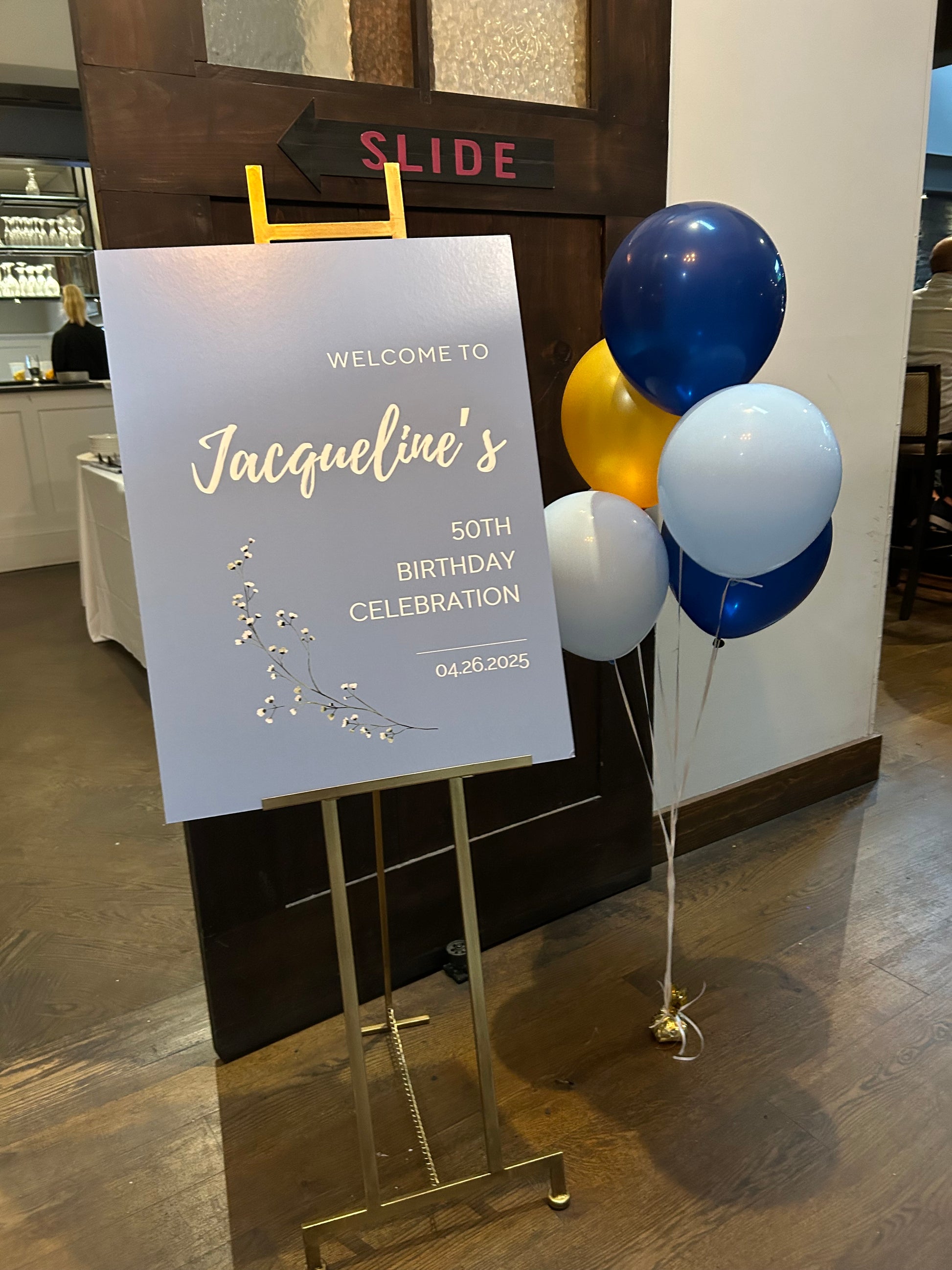 Event Entrance Sign for a birthday celebration with balloons on a table.